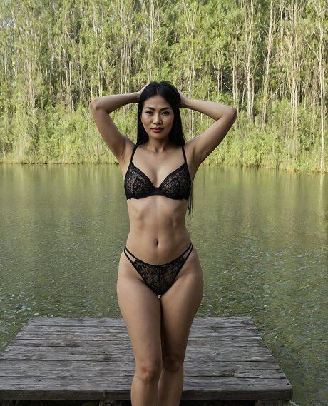 Dark-haired Asian mature woman gets completely naked near a body of water - #10