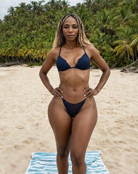 Black model with a fit figure poses on a beach in various stages of undress - pornpics.com on pornsimulated.com
